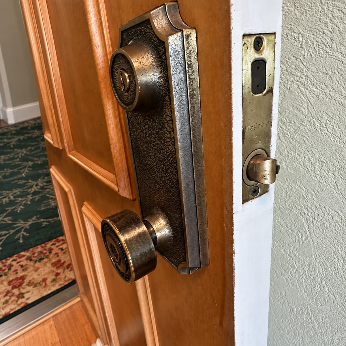 Bronze-colored lock trim and knob on a wooden door